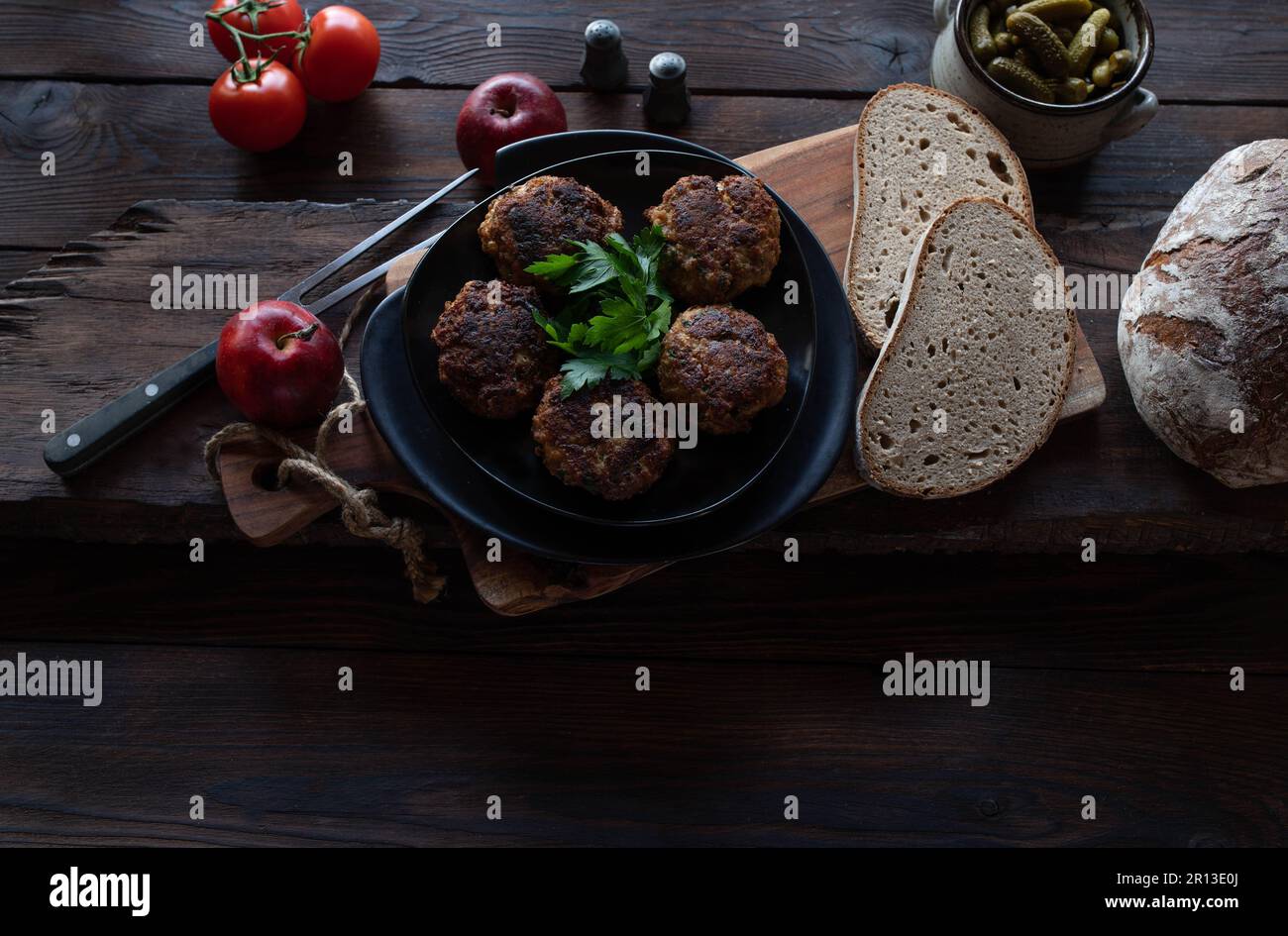 Rustikales Brotgericht mit deutschen Schweinefleischklößchen oder Kühlschrank auf rustikalem und dunklem Holztisch Stockfoto