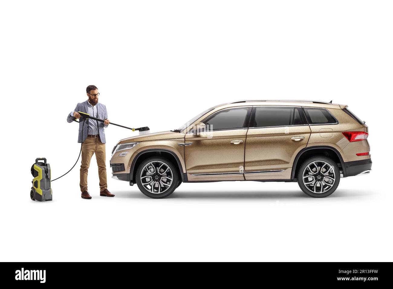 Profilaufnahme über die gesamte Länge eines Mannes, der einen Hochdruckreiniger benutzt und seinen SUV isoliert auf weißem Hintergrund putzt Stockfoto
