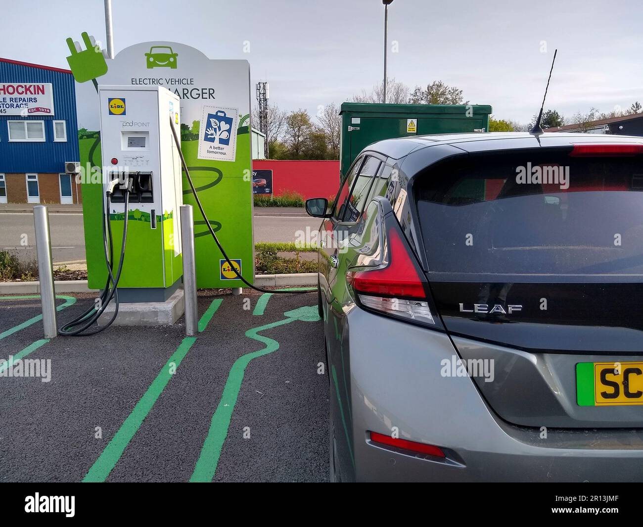 Ein Nissan Leaf Elektrofahrzeug, das an einem Schnellladegerät in einem Lidl Supermarkt in Barnstaple, North Devon, England, aufgeladen wird. Stockfoto
