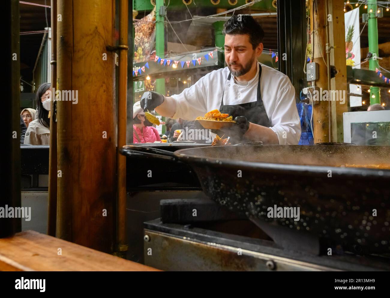 London, England, Großbritannien. Stadtmarkt, Southwark. Ein Mann, der Paella kocht und verkauft Stockfoto
