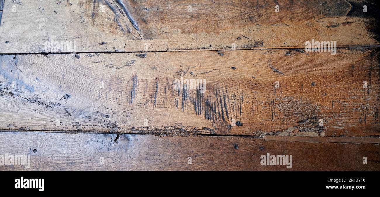 Adze-Zeichen (die schwarzen Linien im Holz) in den englischen Eichenbodenbrettern aus dem 17. Jahrhundert, die in den 1600er Jahren im Zeitraum QE1 verlegt wurden Stockfoto