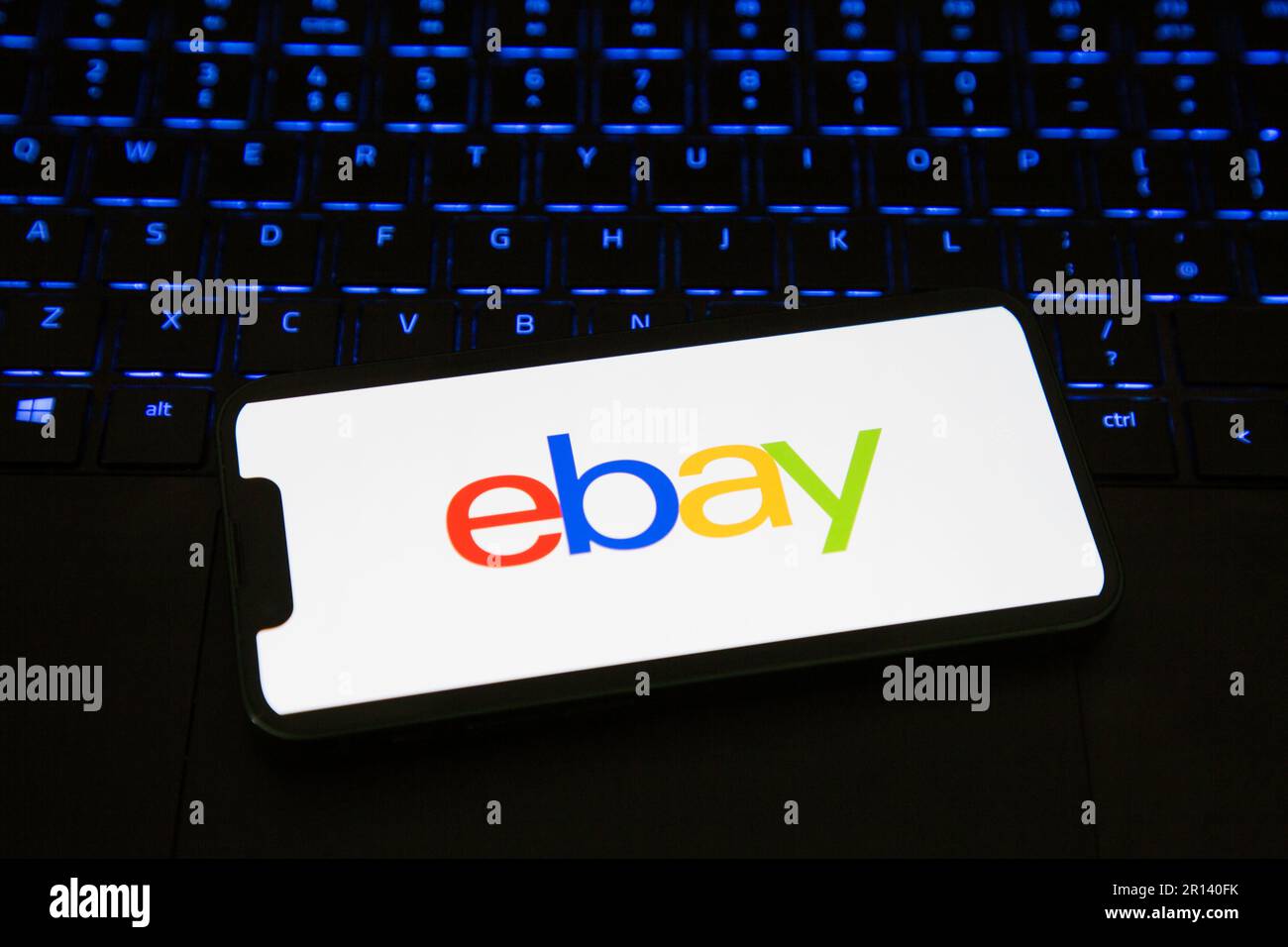 EBay iPhone App wird auf einem Mobiltelefon geladen, das auf einer Tastatur sitzt Stockfoto