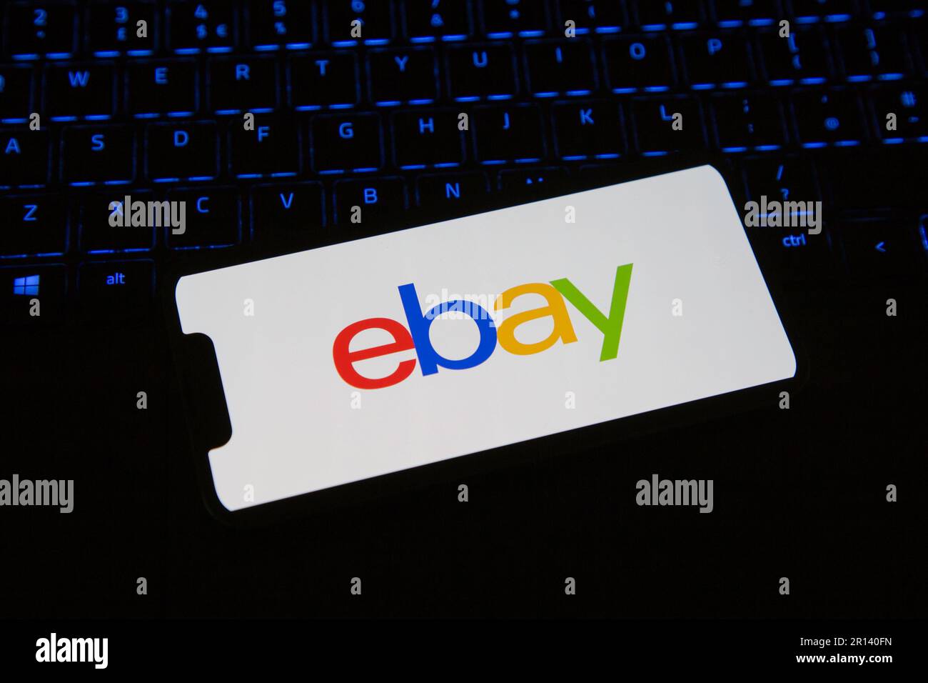 EBay iPhone App wird auf einem Mobiltelefon geladen, das auf einer Tastatur sitzt Stockfoto