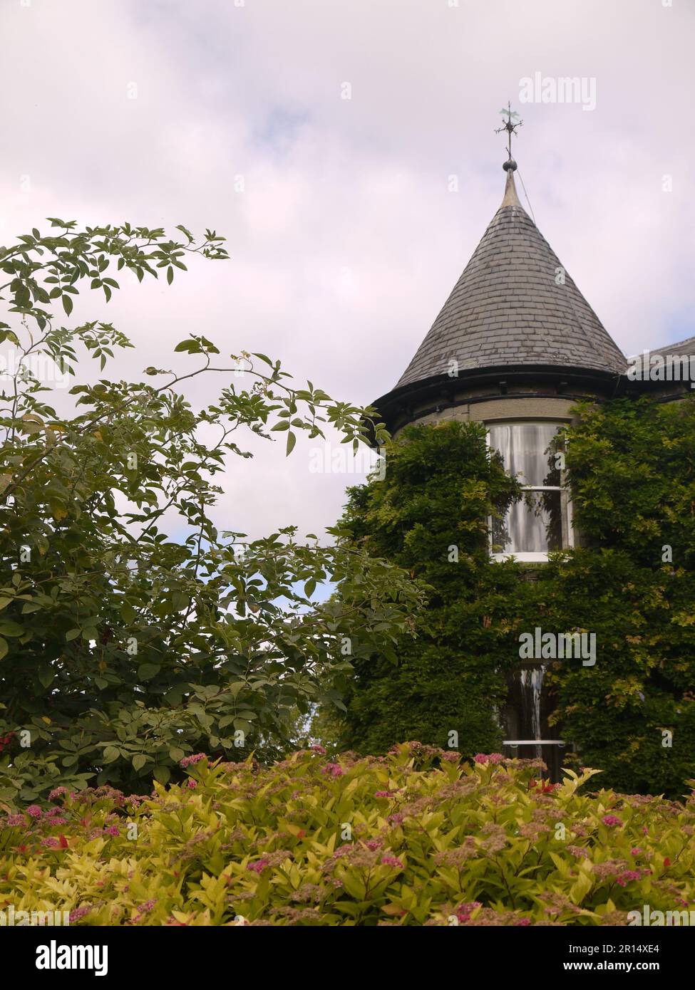 Der mit Wisteria überdachte Turm und die Wetterfahne des Brobury House, Herefordshire, Großbritannien, aus der Sicht der Gärten Stockfoto