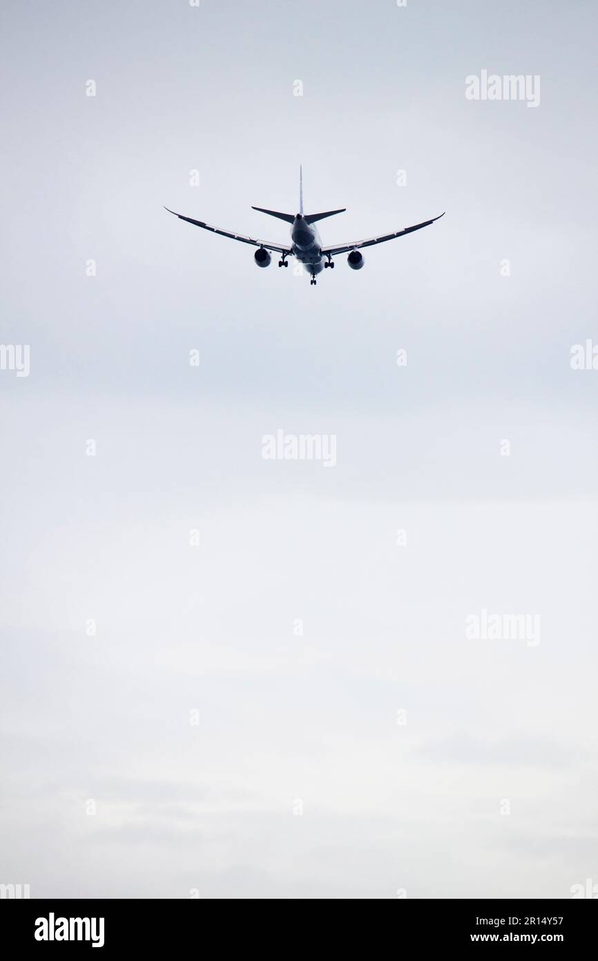 Passagierflugzeug startet im dunklen, wolkigen Himmel Stockfoto