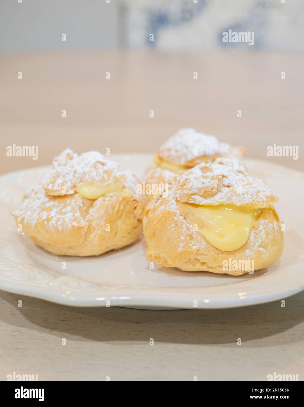 Drei Sahnepuffs, Pate a Choux, gefüllt mit Vanillecreme Pudding und gestreut mit Puderzucker. Süßes Dessert. USA. Stockfoto