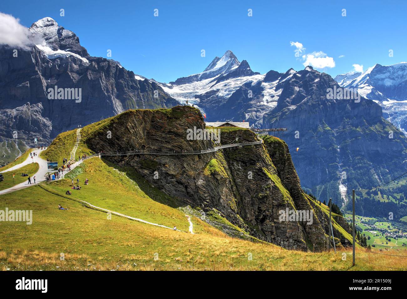 Sommerblick an der Grindelwald-ersten Station über dem Ferienort Grindelwald mit dem Cliff Walk vor dem Hintergrund der Berner Alpen und des Schreckhorn-Gipfels. Stockfoto