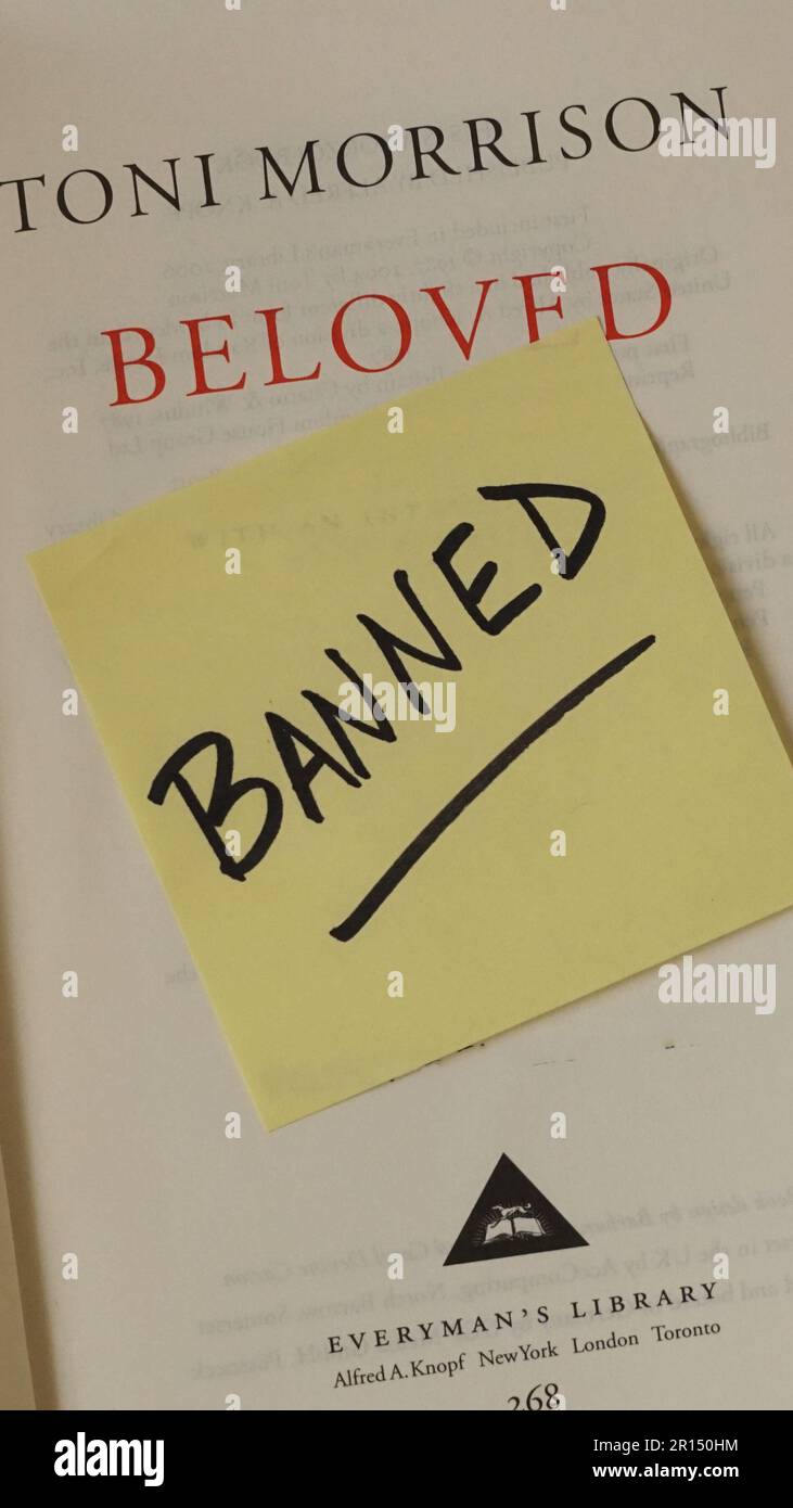 Innenseite des Titels von Toni Morrison's Beloved mit einem Zettel mit der Aufschrift „Banned“. Das Buch ist häufig auf den Listen verbotener Bücher für Schulen und Bibliotheken zu finden. Stockfoto