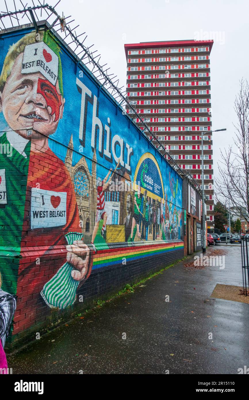 Wandgemälde an der Straßenecke mit Divis Tower im Hintergrund auf der Divis Street (dem unteren Abschnitt der Falls Road) in West Belfast, Nordirland, Großbritannien Stockfoto