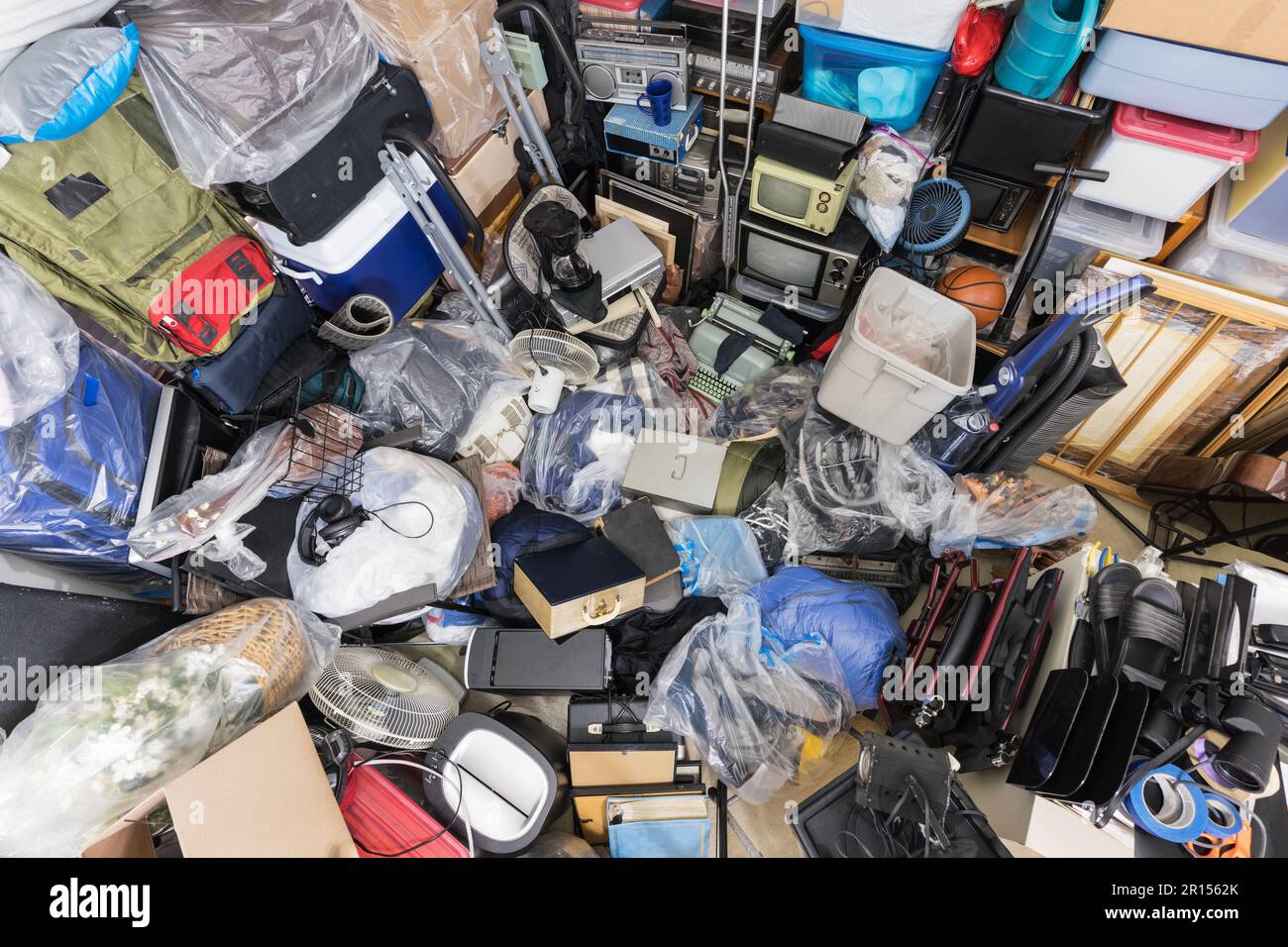 Schrotthaufen mit Kleidertaschen, Haushaltsgegenständen, alter Elektronik und verschiedenen Gegenständen. Stockfoto