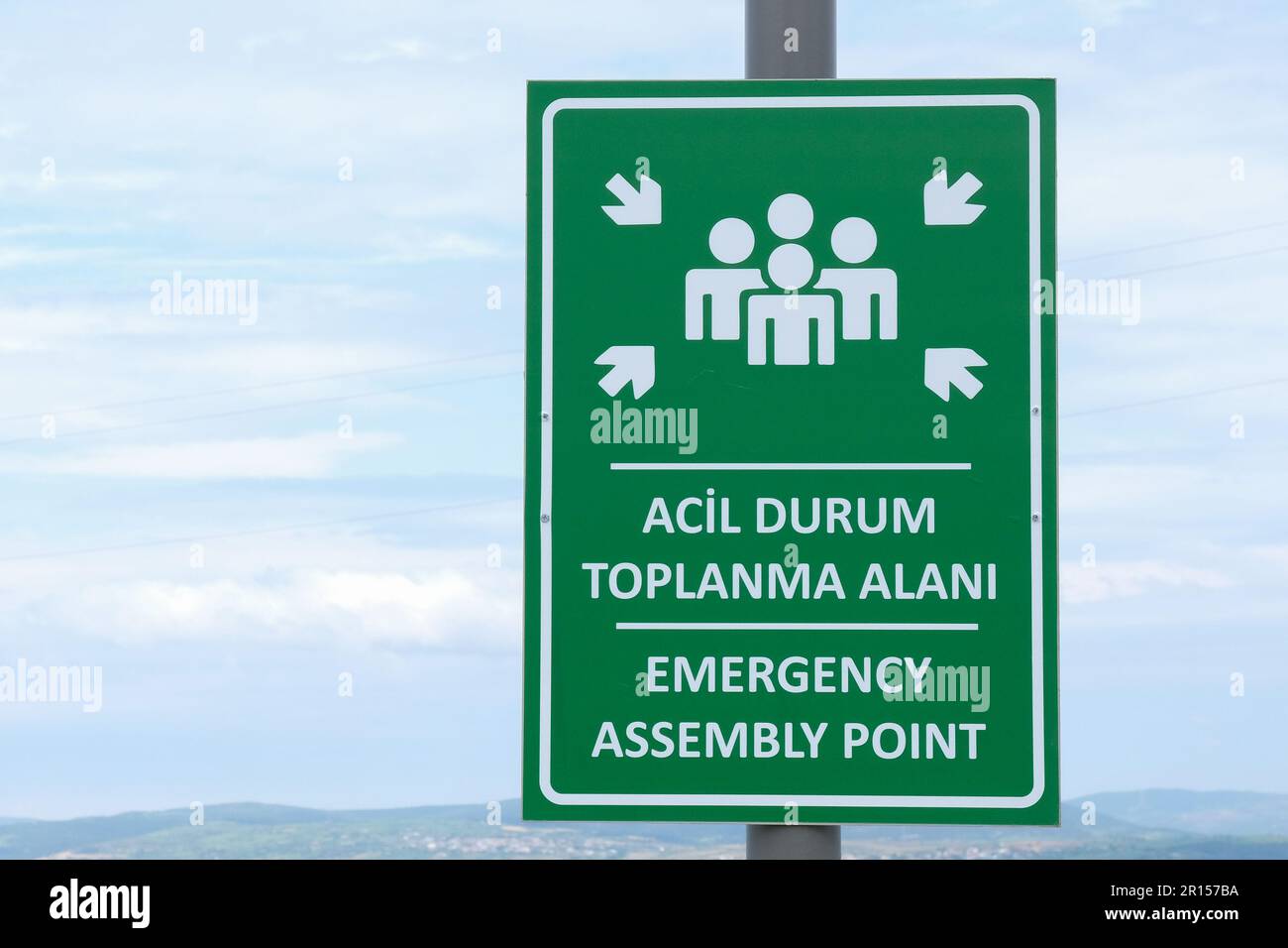 Nahaufnahme Notfall Sammelpunkt Schild mit Himmelshintergrund. ACIL Durum Toplanma Alanı bedeutet in türkischer Sprache. Stockfoto