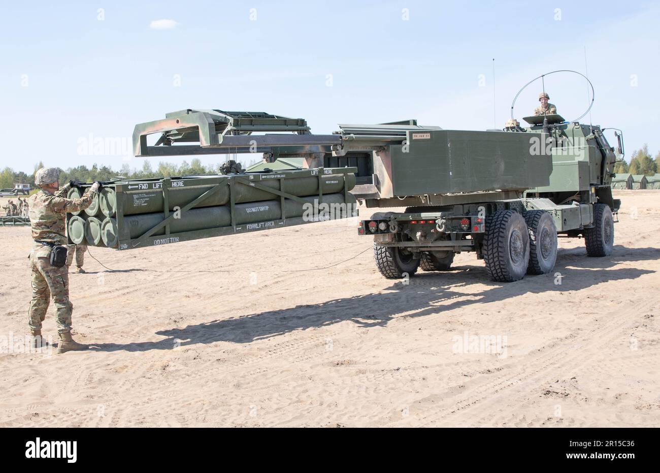 USA Army Sergeant Tyler Finney ist gegangen, Sektionschef 1-182., Field Artillery Regiment, entlädt eine Trainingspalette mit Raketen für das M142 High Mobility Artillery Raketensystem, während US Der Fahrer beobachtet Maxx Albrecht auf der taktischen Vorwärts-Einsatzstelle Adazi, Lettland, 09. Mai 2023. Die Soldaten bereiten ihre Ausrüstung für ein Live-Feuerereignis vor, um Defender 23 zu unterstützen. Defender ist eine multinationale, gemeinsame Übung, die darauf abzielt, Bereitschaft und Interoperabilität zwischen Verbündeten und Partnern aus den USA, der NATO und der NATO aufzubauen. Defender demonstriert U.S. Die Fähigkeit der Armee Europas und Afrikas, groß angelegte G zu führen Stockfoto