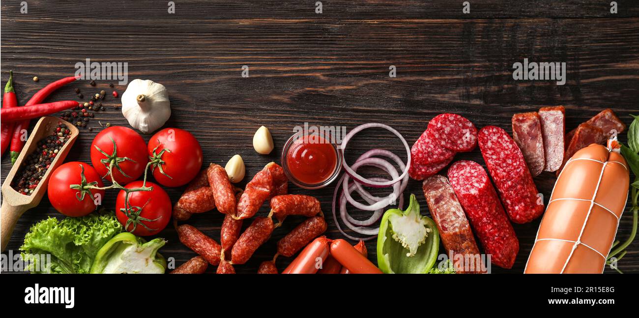Verschiedene Arten von Würstchen mit Sauce, Gewürze und Gemüse auf Holz- Hintergrund Stockfoto
