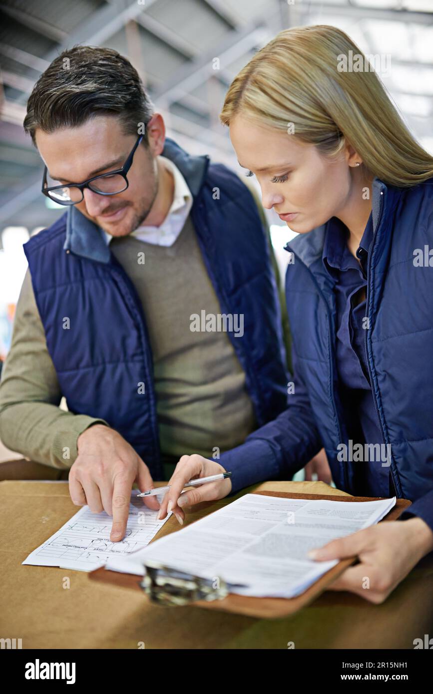 Sicherstellen, dass die Befehle pünktlich erteilt werden. Zwei Kollegen, die ein Lager leiten. Stockfoto