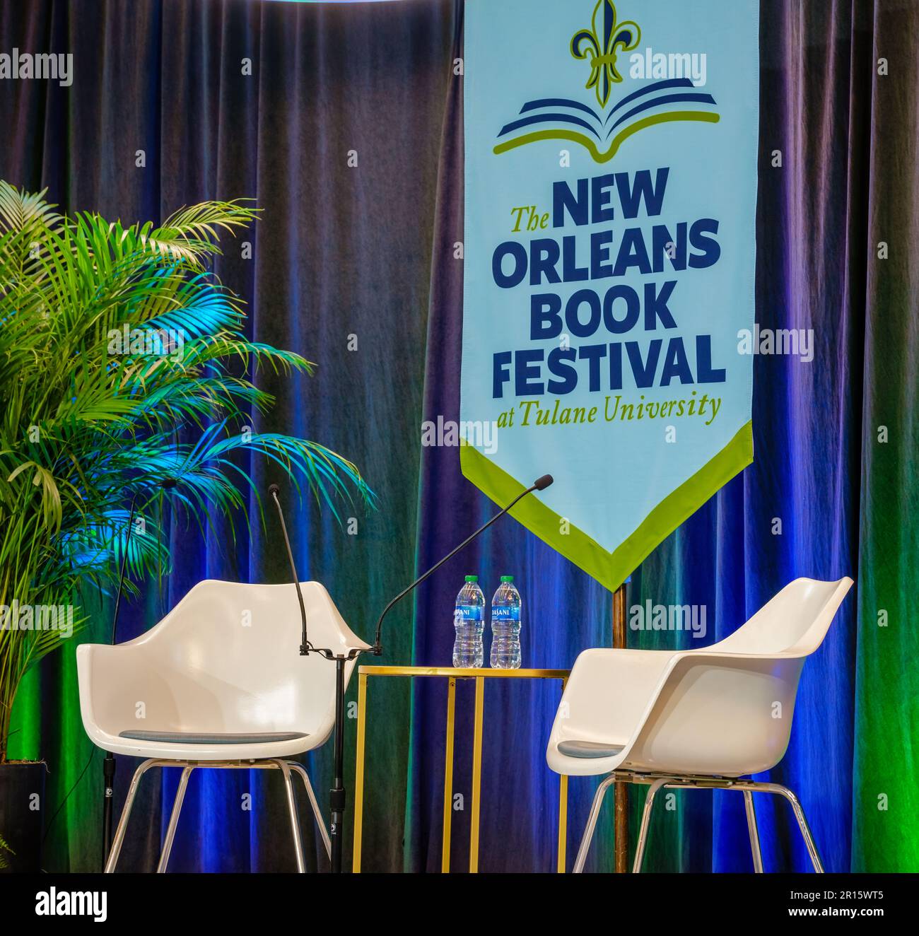NEW ORLEANS, LA, USA - 10. MÄRZ 2023: Zwei Plastikstühle, zwei Flaschen Wasser und ein Banner für das New Orleans Book Festival Stockfoto