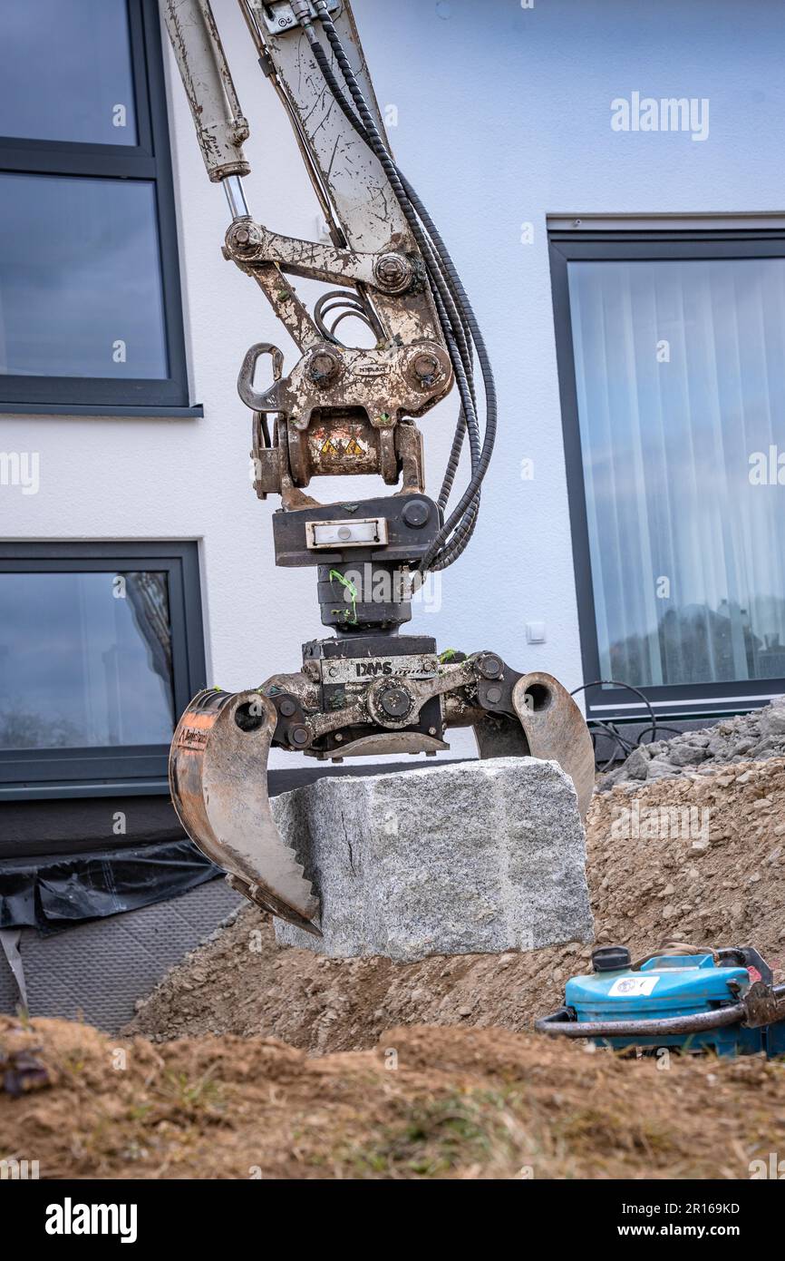 Baggergreifer mit Stein auf Baustelle, Calw, Deutschland Stockfoto