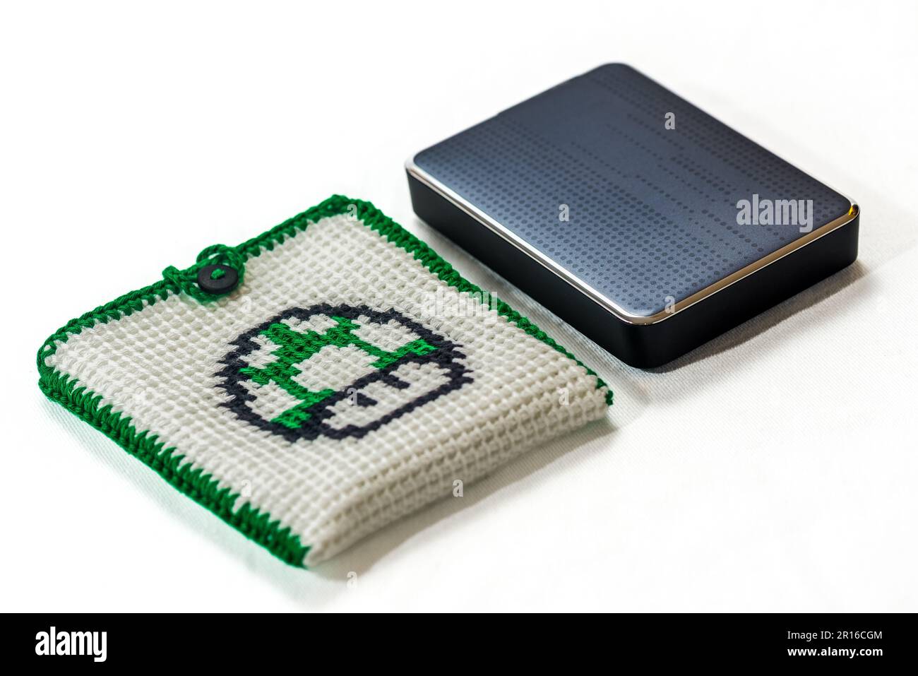 Umschlag für externe Festplatte, gestrickt mit einem grünen Pilz Stockfoto