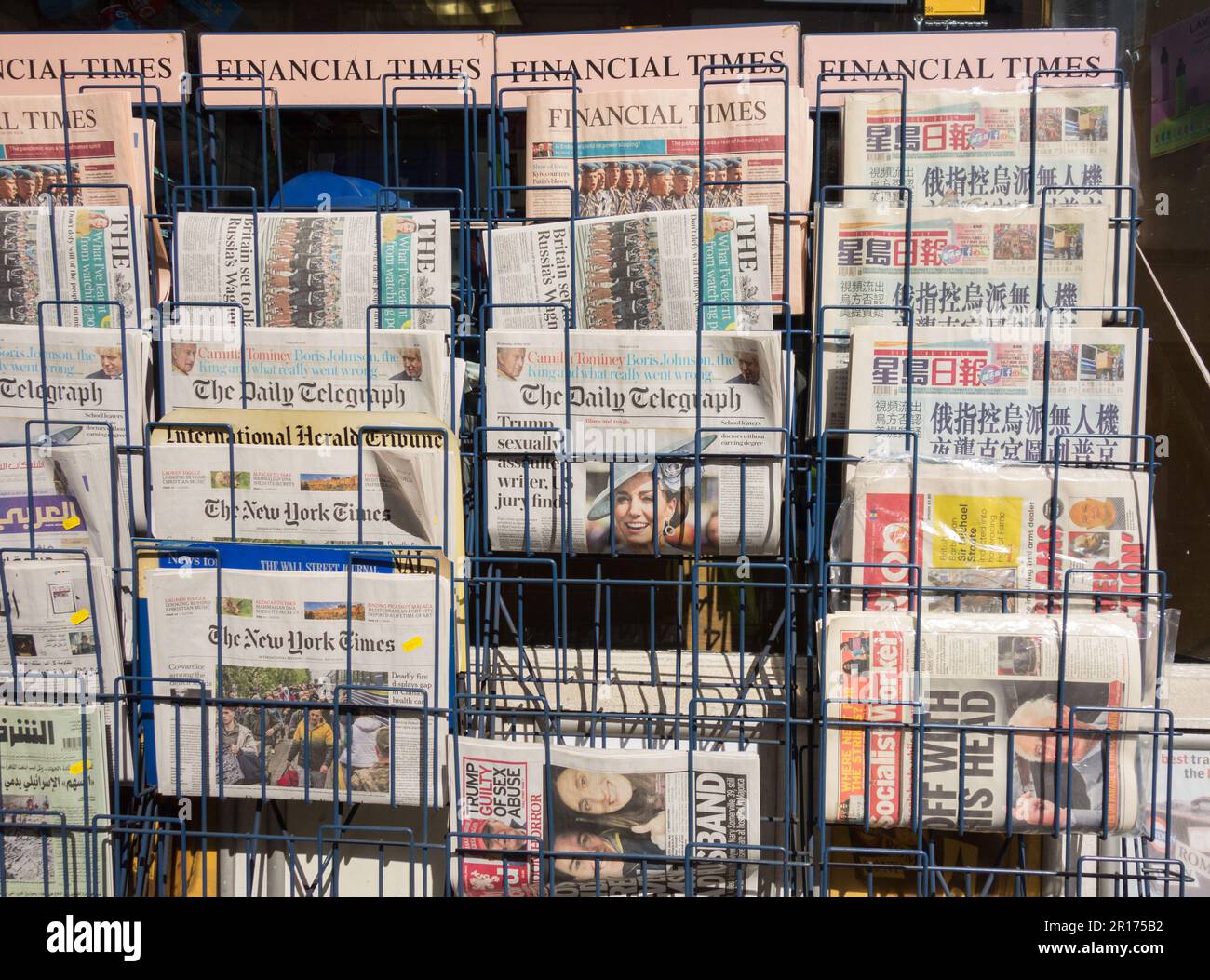 Internationale und britische Zeitungsseiten und Kopfzeilen vor einem Zeitungsgeschäft im Zentrum Londons, England, Großbritannien Stockfoto
