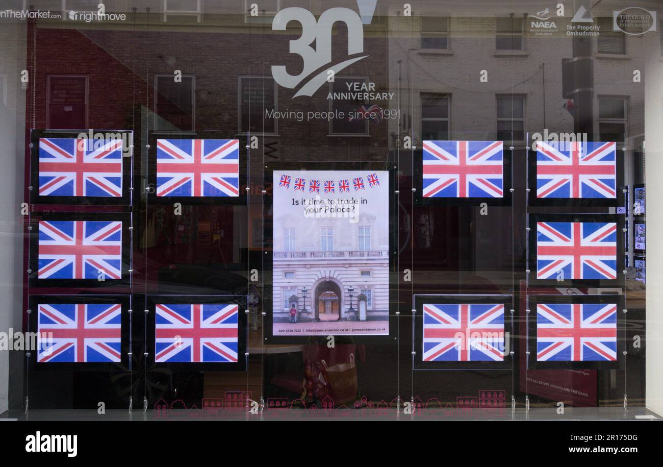 Ein Schaufenster eines Immobilienmaklers mit King Charles' 111 Royal Coronation Celebration Bbunting und Union Jacks, London, England, Großbritannien Stockfoto
