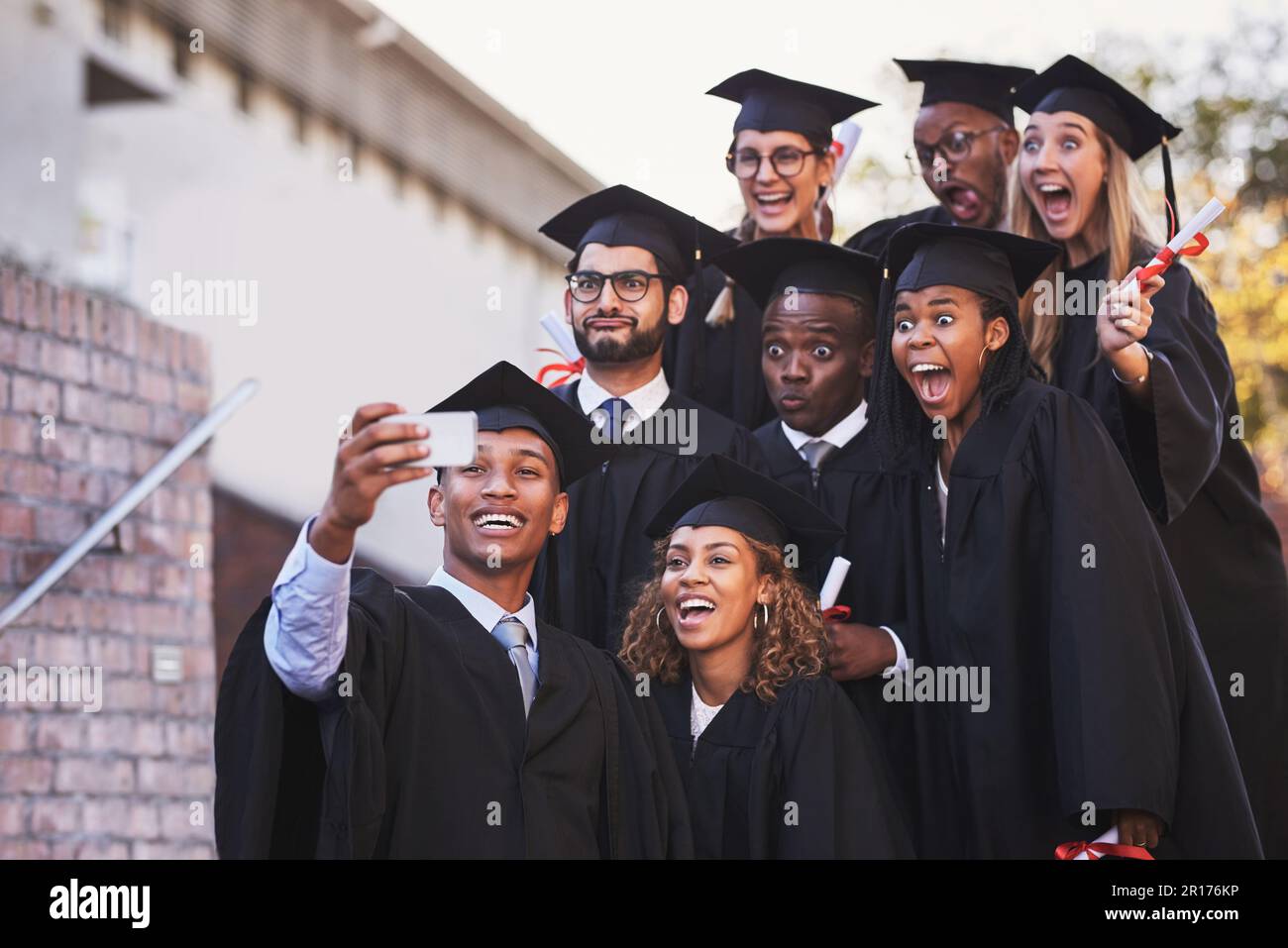 Das ist ein Bild von Beharrlichkeit. Eine Gruppe von Schülern, die am Abschlusstag ein Selfie machen. Stockfoto