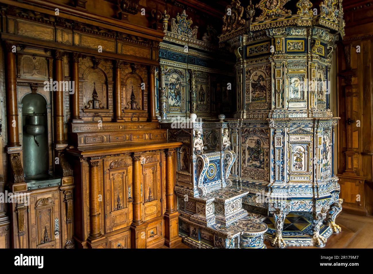 Zimmer mit Holztäfelung und traditionellem Kachelofen (Kokofen), großer Heizelement umgeben von Keramikfliesen, Schweizer Nationalmuseum, Zürich, Stockfoto