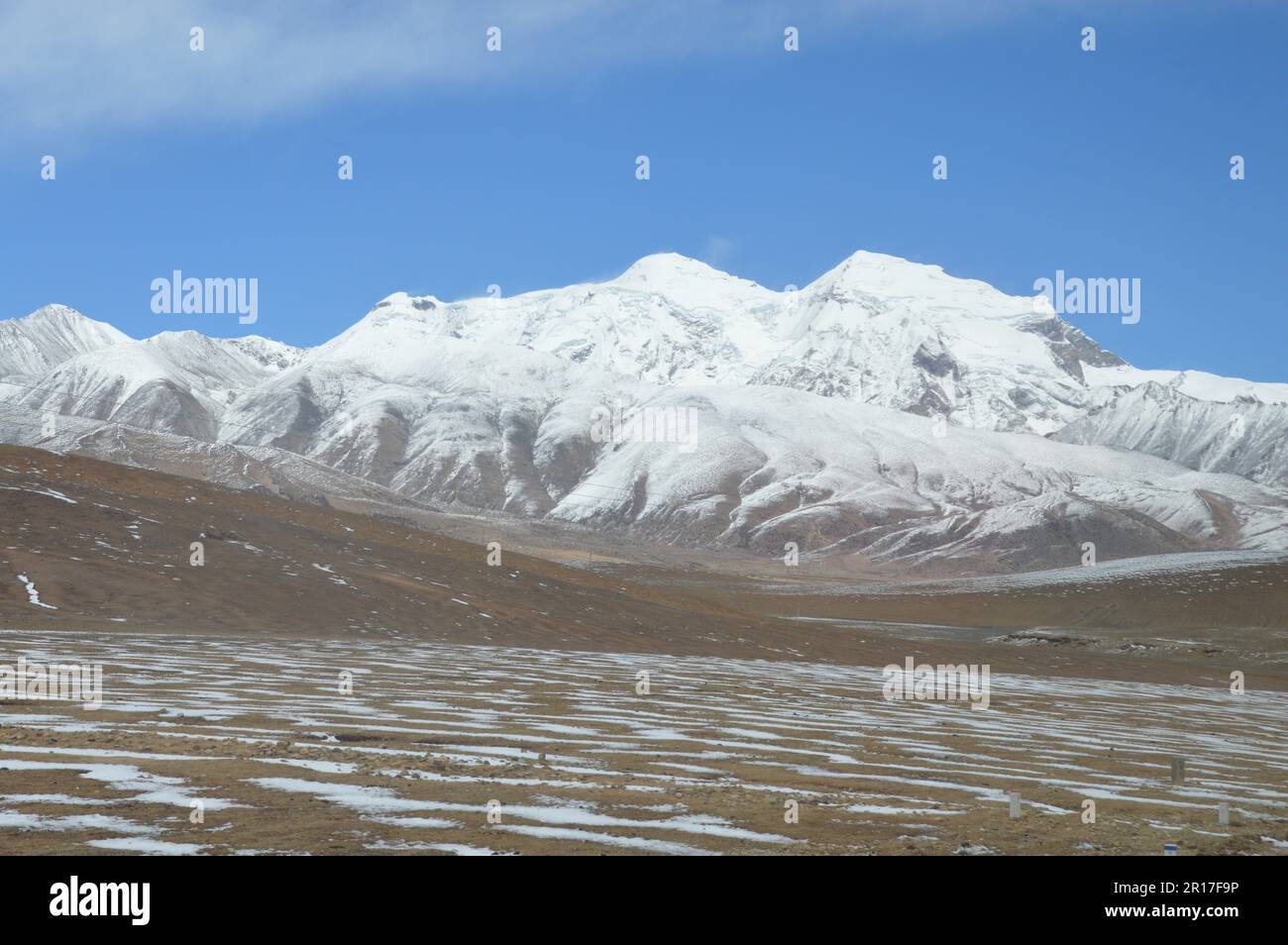 Volksrepublik China, Tibet: Die Schneelinie auf dem Hochplatau mit schneebedeckten Bergen als Kulisse. Stockfoto