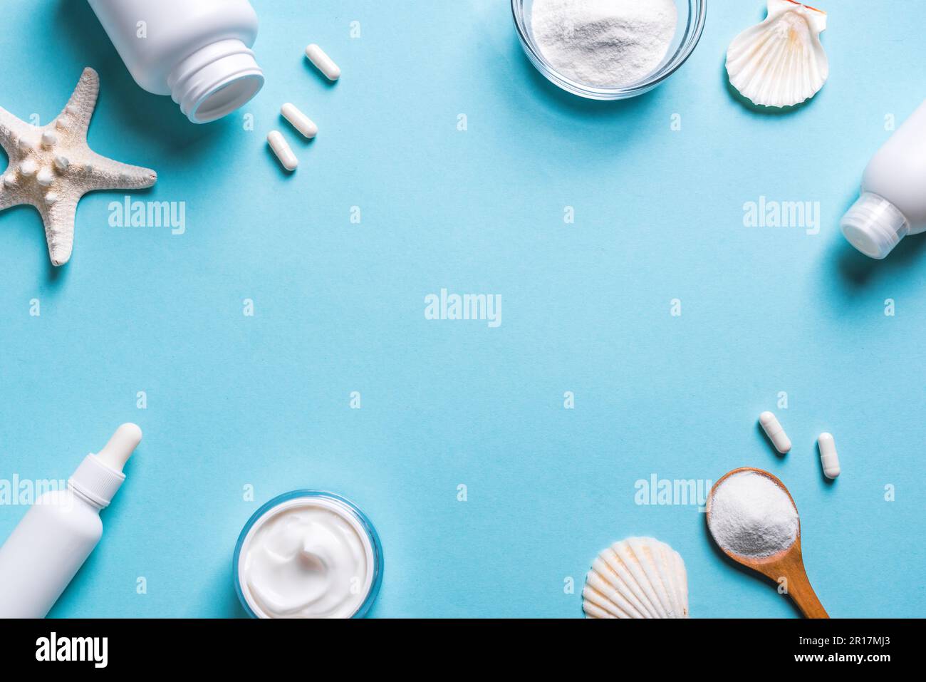 Kollagenpulver und Kollagenkosmetikprodukte - Kapseln (Pillen), Gesichtscreme, Serum auf blauem Hintergrund, Kopierraum. Fischbasiertes Kollagen-Nahrungsergänzungsmittel Stockfoto