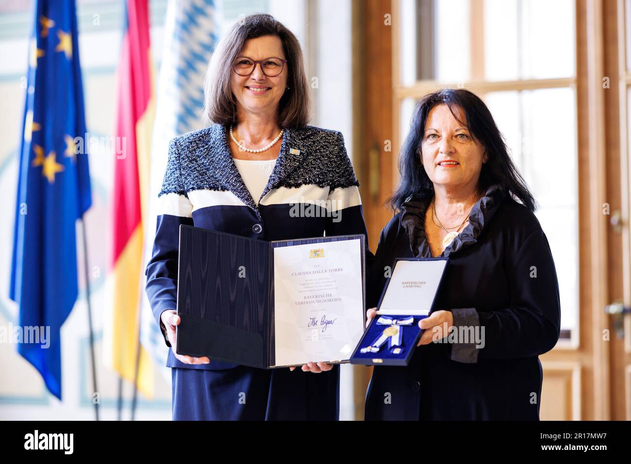 München, Deutschland. 12. Mai 2023. Ilse Aigner (CSU, l), Präsidentin des bayerischen Staatsparlaments, und Claudia Dalla Torre schauen in die Kamera während der Präsentation des bayerischen Verfassungsordens im bayerischen Staatsparlament. Dalla Torre wurde unter anderem für ihr Engagement in der Vereinigung "Frauen helfen Frauen" in Kempten mit der bayerischen Verfassungsordnung ausgezeichnet. Kredit: Matthias Balk/dpa/Alamy Live News Stockfoto