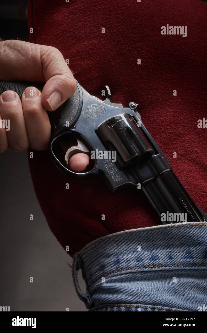 Ein Mann zieht eine verdeckte .41 Magnum Pistole aus seinem Bund Stockfoto