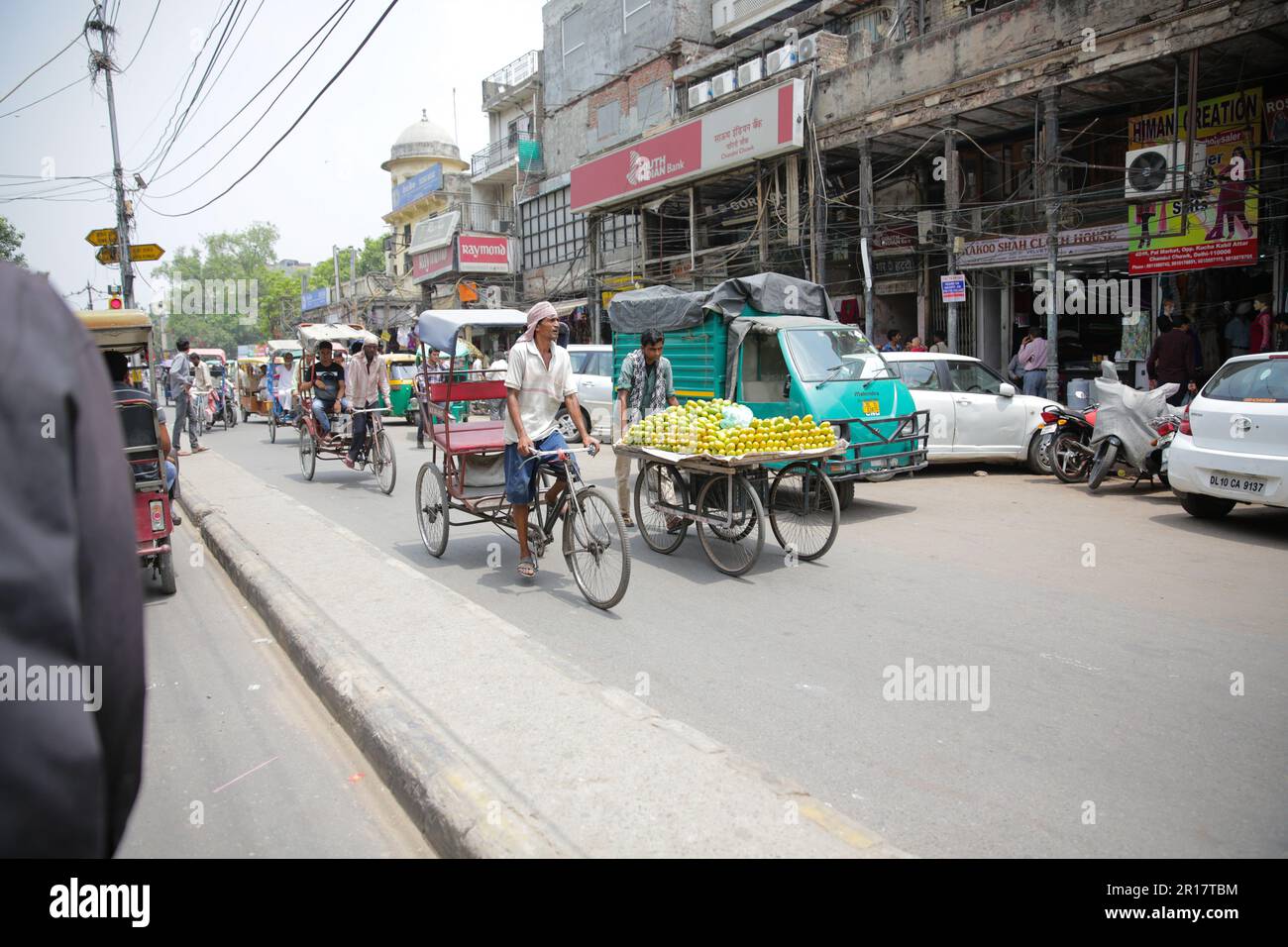Belebte Straße in Delhi mit Tuk Tuks und Market Carts, Indien Stockfoto