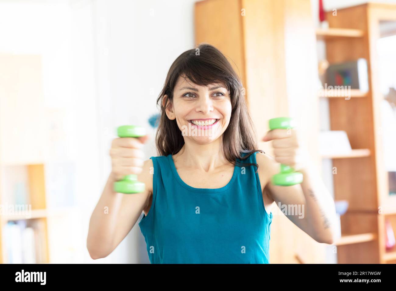 Eine Frau mit langen, offenen Haaren macht sich zu Hause fit Stockfoto