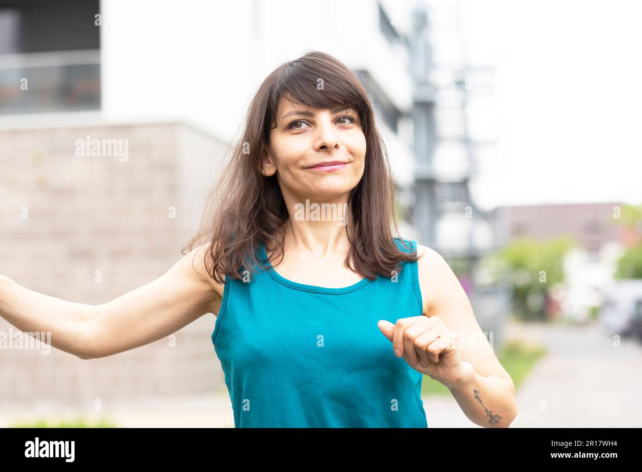 Eine Frau mit langen offenen Haaren, die in der Stadt tanzt Stockfoto