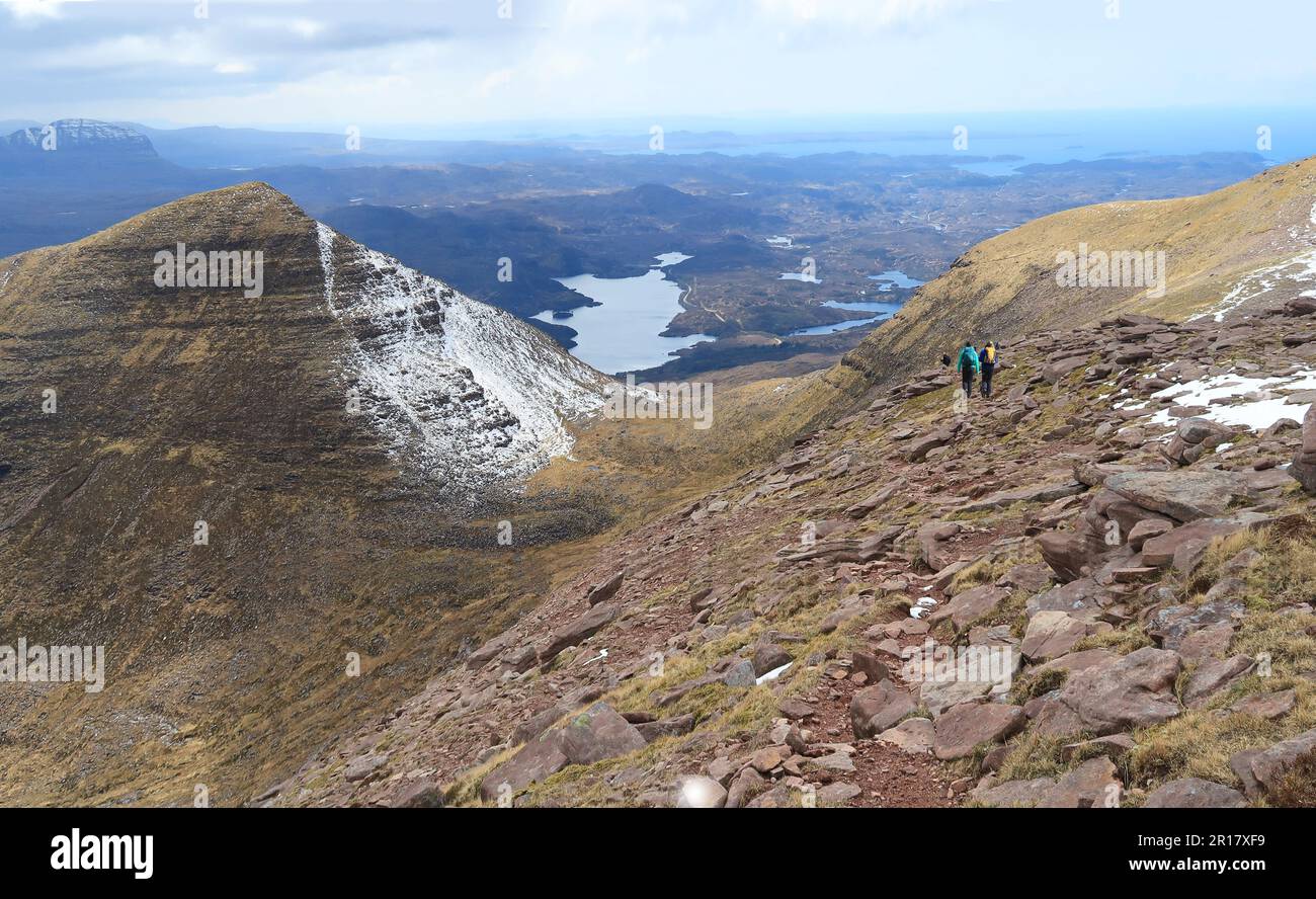 Spaziergänger in der Nähe des Gipfels von Sail Gharbh, einem von 3 Gipfeln des Quinag Berges in Assynt, Schottland. Blick nach Westen in Richtung Küste. Suilven Beyond (ganz links). Stockfoto