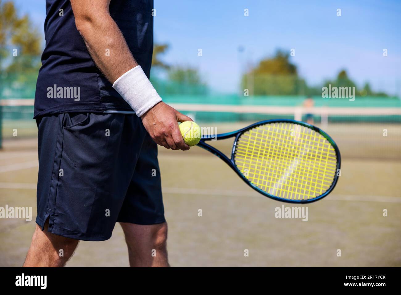 Tennisspieler mit Schläger und Ball in den Händen, bereit zum Spielen auf dem Freiluftplatz Stockfoto