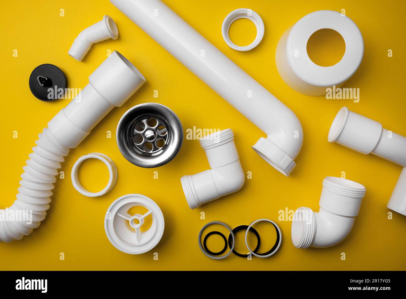 Rohrleitungen, ablaufteile aus pvc-Kunststoff auf gelbem Hintergrund. Draufsicht Stockfoto