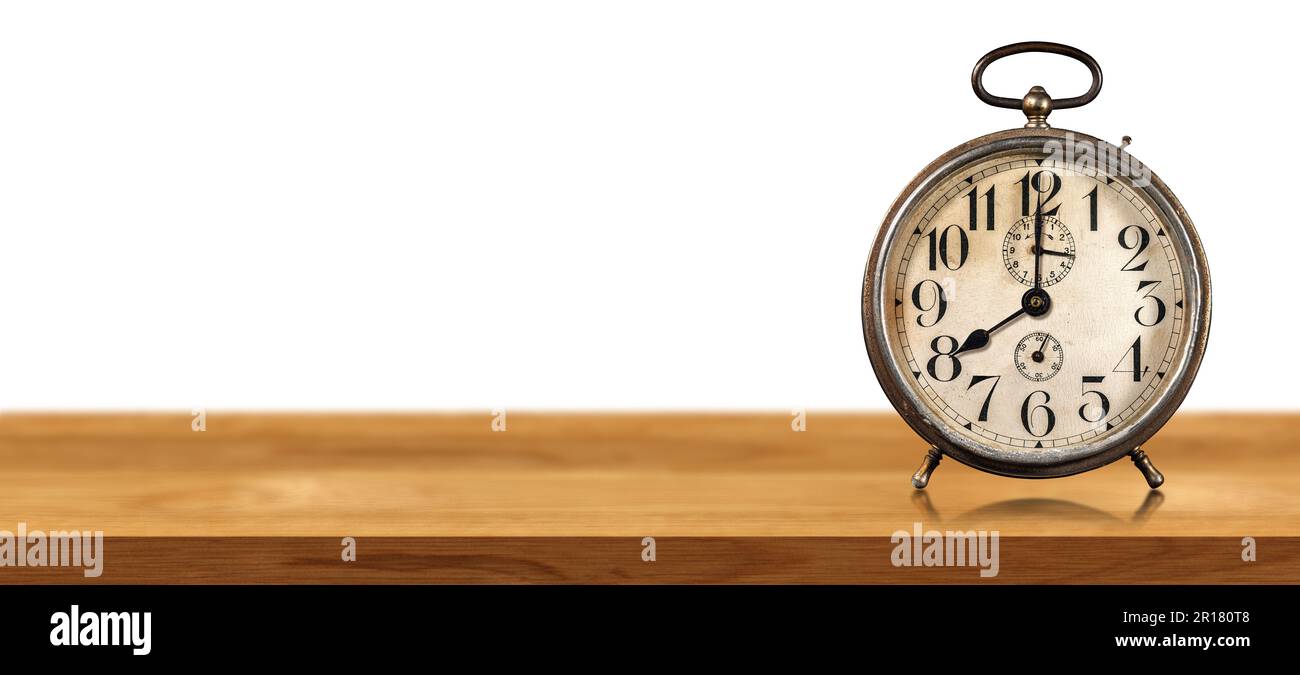 Nahaufnahme eines alten Weckers auf einem Holztisch isoliert auf weißem Hintergrund mit Kopierraum. Acht Uhr, Italien. Stockfoto