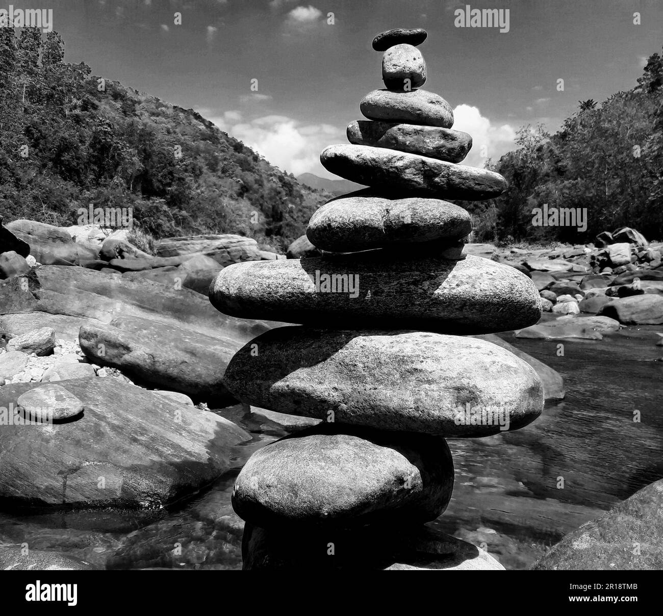 Steinhaufen in einem Seehintergrund. Nahaufnahme einer Steinwaage. Schwarz und Weiß Stockfoto