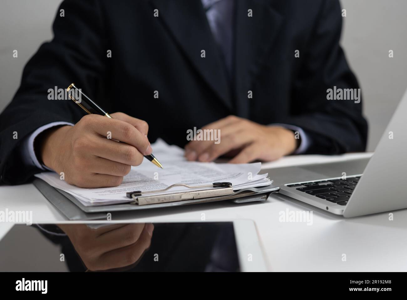 Ein Geschäftsmann hält eine Unterschrift mit einem Stift oder unterschreibt ein Vertragsrechtsdokument. Ein Mitarbeiter verfasst eine Vereinbarung, um die Bewerbung zu dokumentieren. Stockfoto
