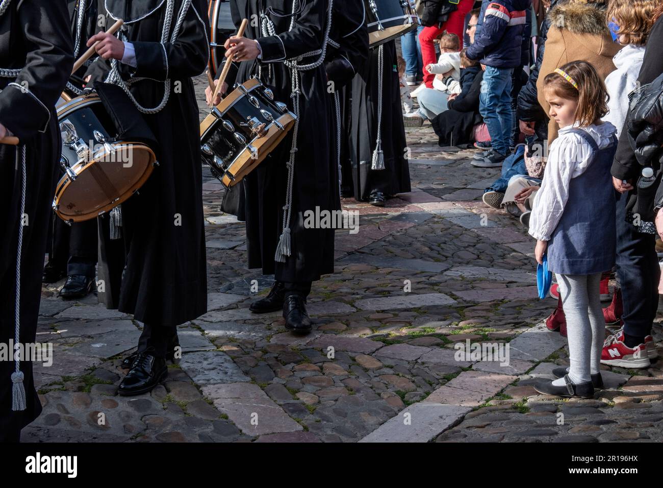 Ein Mädchen schaut sich die Band of Bugles and Drums von Cristo de la Victoria während Semana Santa, Leon, Spanien an Stockfoto