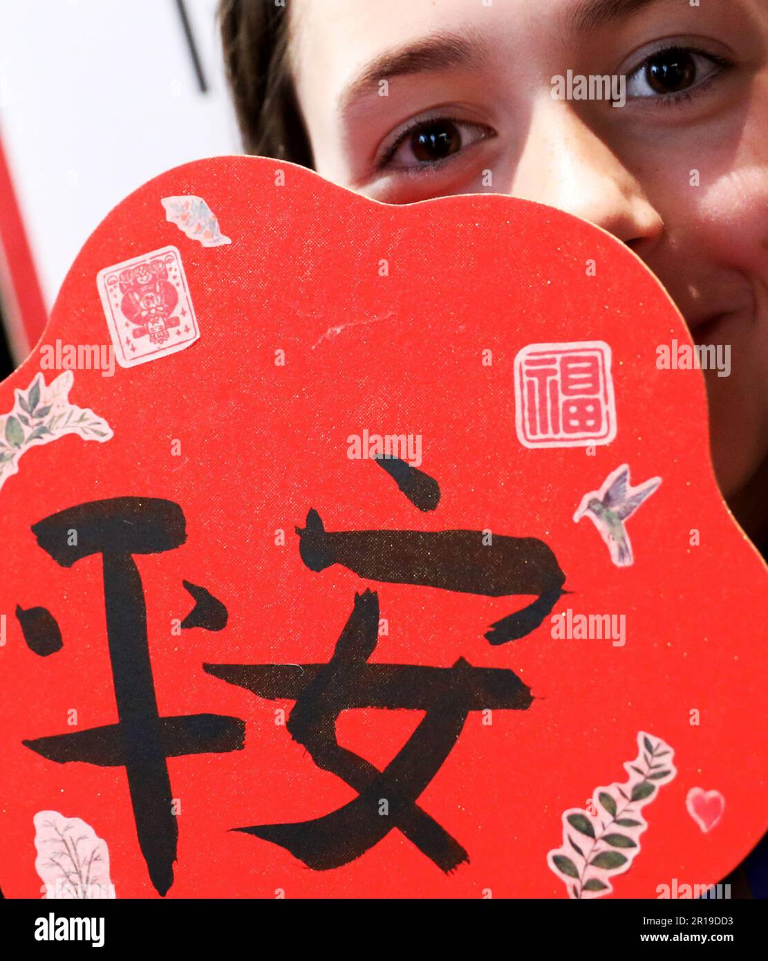 London, Großbritannien. 11. Mai 2023. Eine Schülerin zeigt ihre Kalligraphiearbeit mit chinesischen Schriftzeichen „Ping an“, was sicher und gesund auf Englisch bedeutet, in London, Großbritannien, 11. Mai 2023. Mehr als 100 britische Schüler und Lehrer der Sekundarstufe nahmen an einem internationalen Chinesischen Sprachtag hier am Donnerstag Teil. Kredit: Li Ying/Xinhua/Alamy Live News Stockfoto