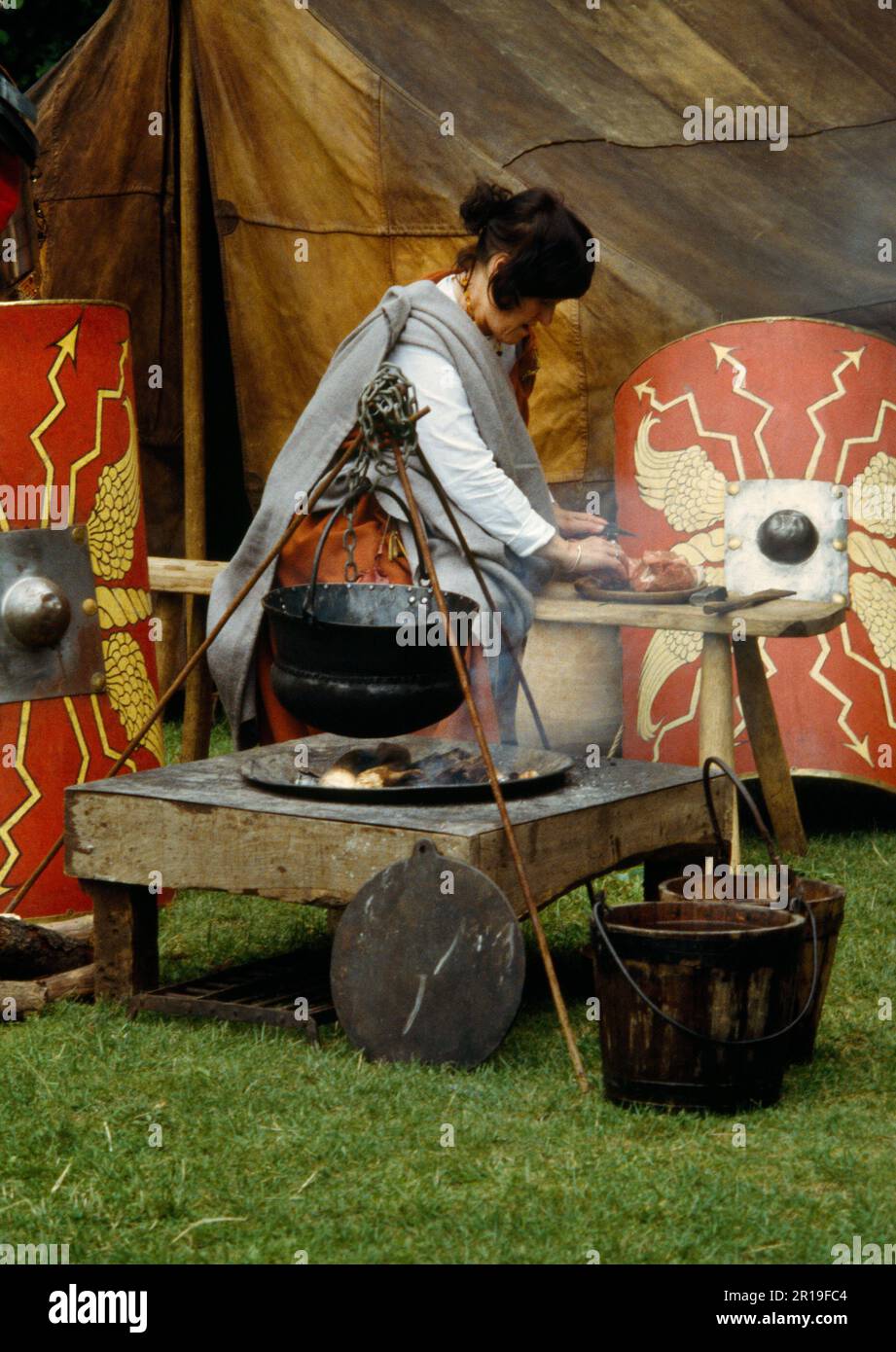 Zubereitung und Kochen von Fleisch in einem Kessel über einem Holzfeuer während einer Ausstellung der Ermine Street Guard im Loggerheads Country Park, North Wales, Großbritannien Stockfoto