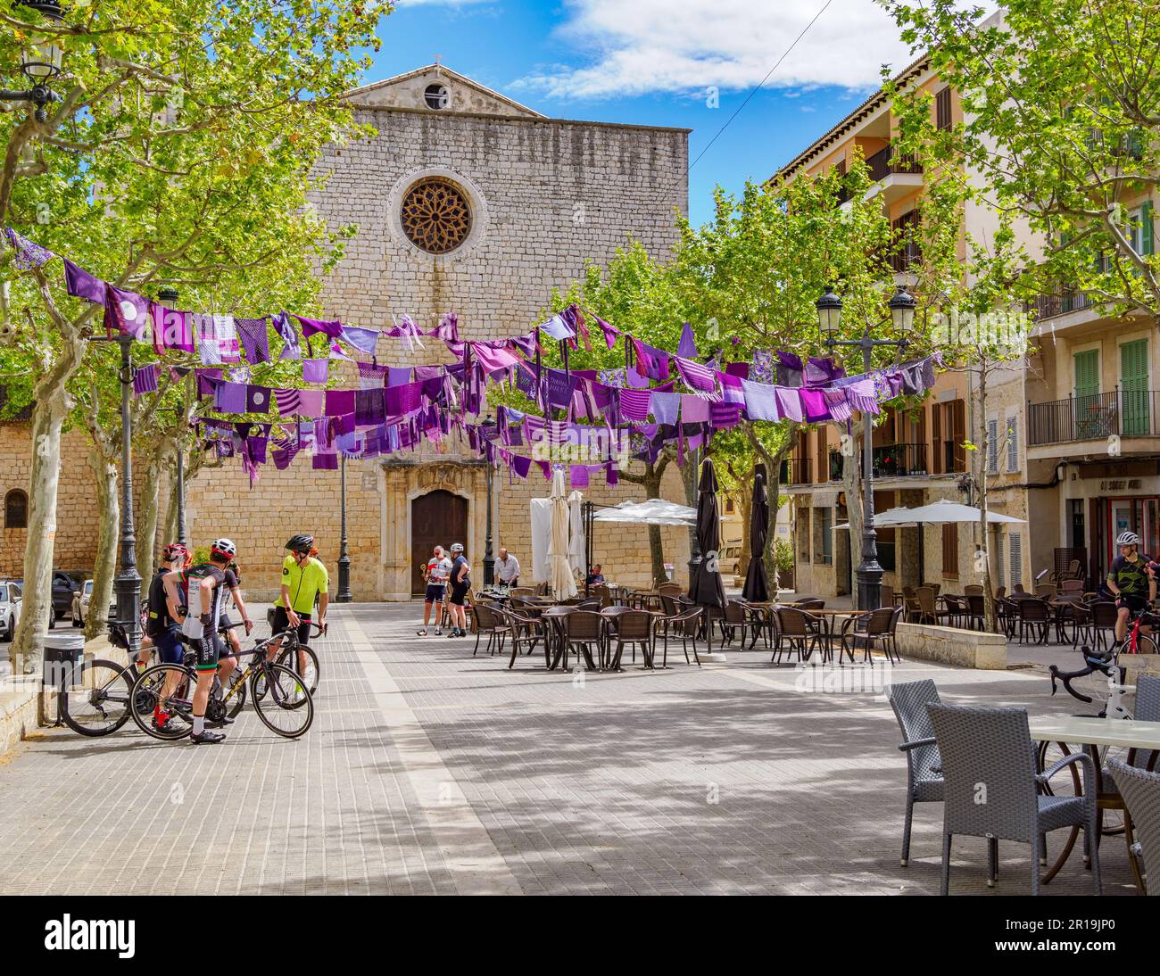 Hauptplatz des Dorfes Alaro in den Tramuntana-Bergen Mallorcas, Spanien, mit lila Flaggen für den Frauentag Stockfoto
