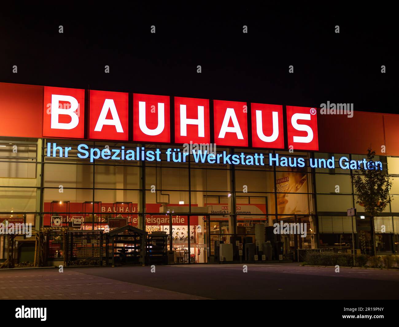 Bauhaus Baumarkt Eingang bei Nacht. Beleuchtetes Logo des Einzelhandelsgeschäfts für Handwerker und Gärtner. Ausstattung für Heimwerkerbedarf. Stockfoto