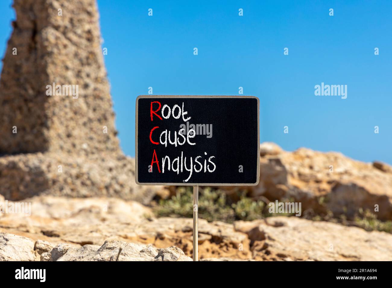 Symbol für RCA-Ursachenanalyse. Konzeptbegriffe RCA-Ursachenanalyse auf wunderschöner schwarzer Kreidetafel. Wunderschöner Steinstrand im Hintergrund. Geschäftlich Stockfoto