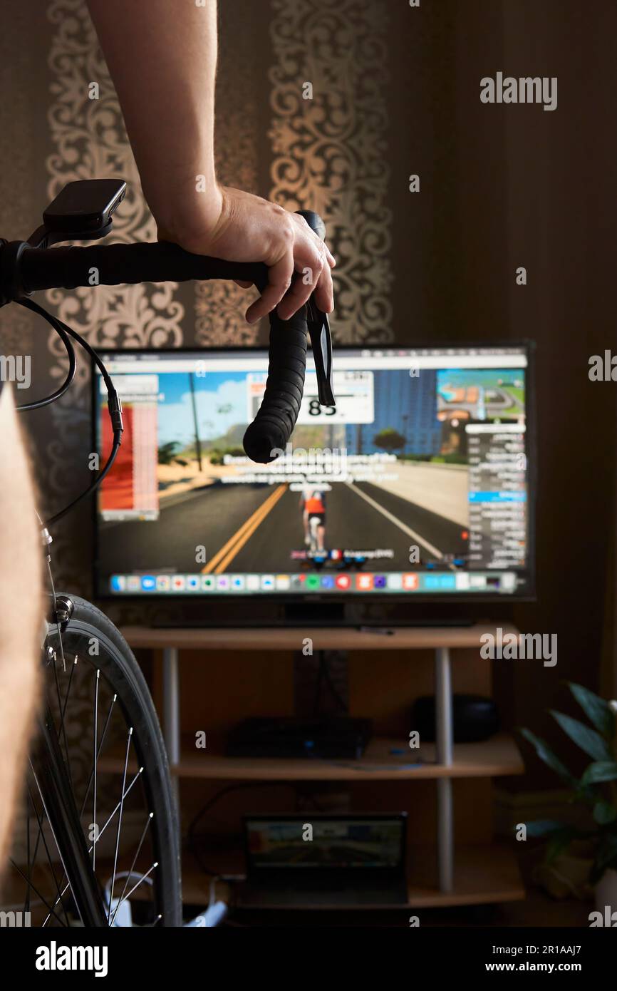 Radfahrer trainiert auf dem Fahrrad mit einem Fernseher beim  Online-Radfahren. Bleiben Sie zu Hause fit und aktiv. Indoor Cycling im  Winter Stockfotografie - Alamy