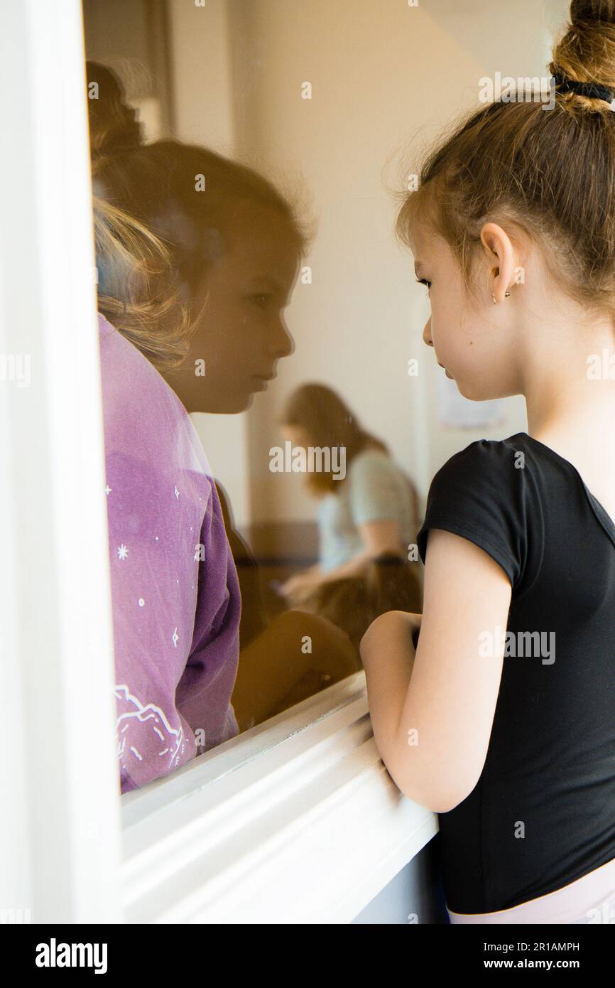 Mädchen-Reflexion, die Tanzunterricht durch ein Fenster gucken Stockfoto