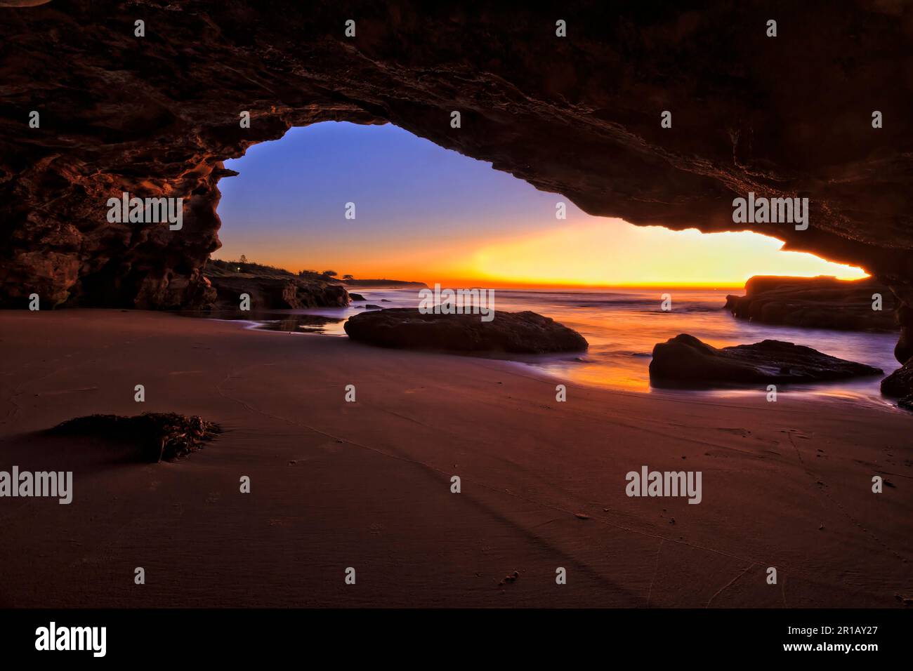 Sonnenaufgang von der Meereshöhle am Caves Beach in Australien - malerische Meereslandschaft der Pazifikküste. Stockfoto