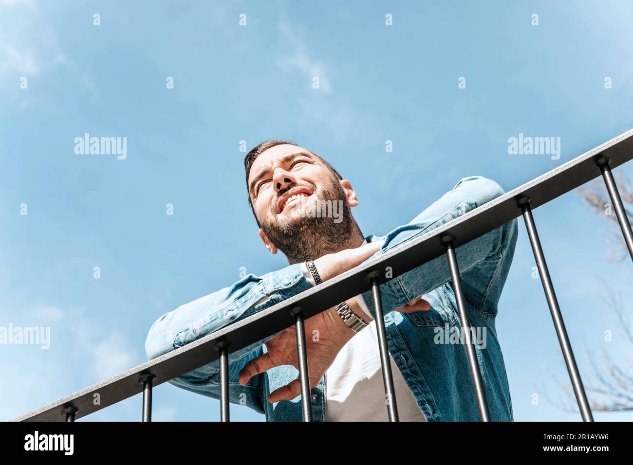 Porträt eines attraktiven Hipstermannes in einer jeansjacke. Ein Mann in einer großen Stadt auf der Straße, ein Lebensstil-Konzept Stockfoto