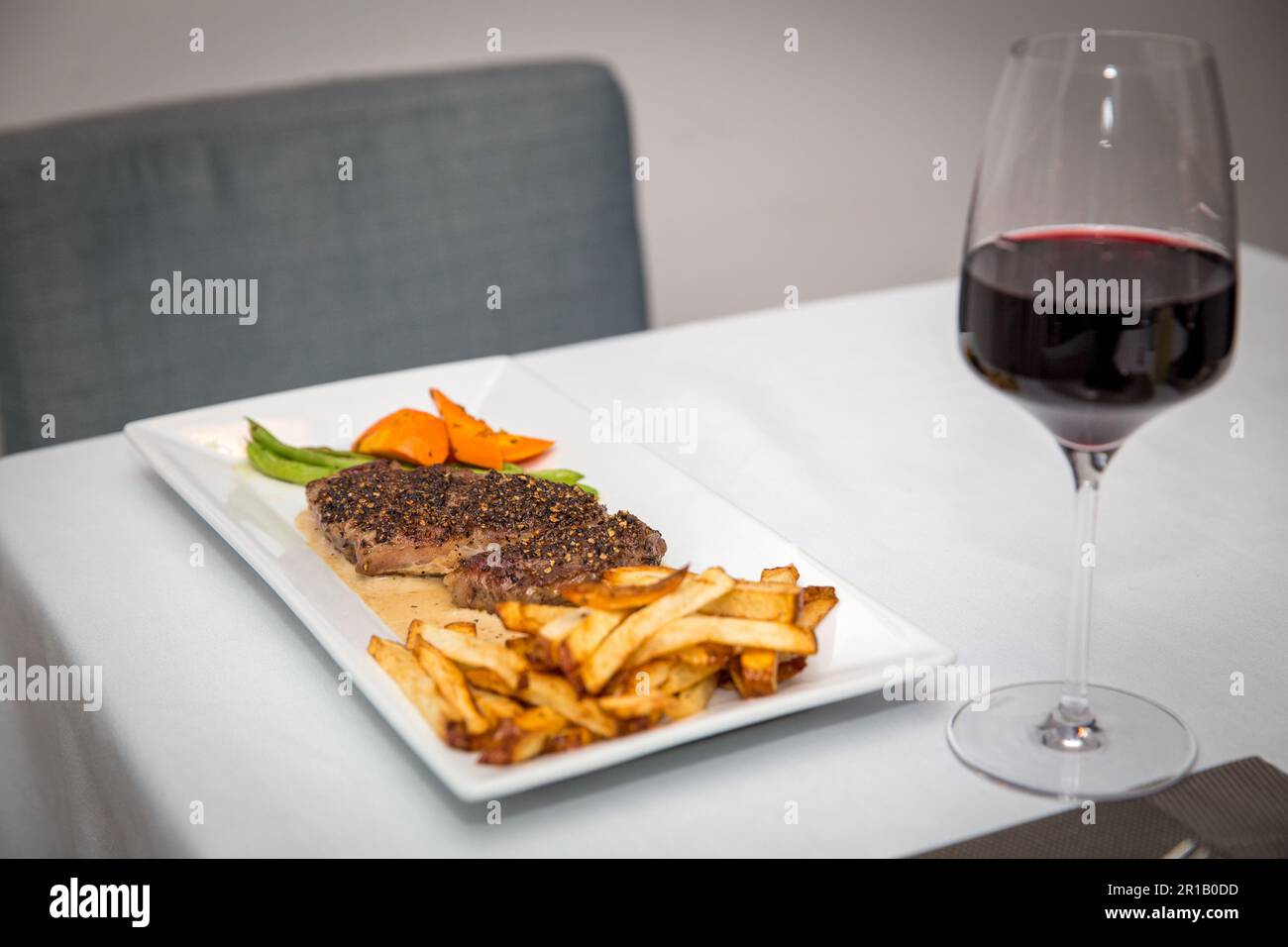 Steak und Pommes Frites mit Rotwein zum Abendessen Stockfoto