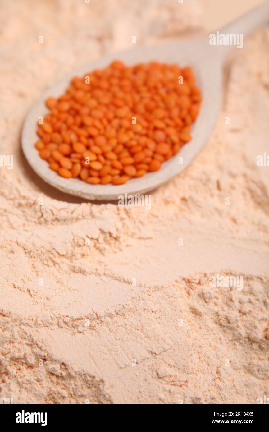 Löffel mit Linsenkörnern auf Mehl, Nahaufnahme Stockfoto
